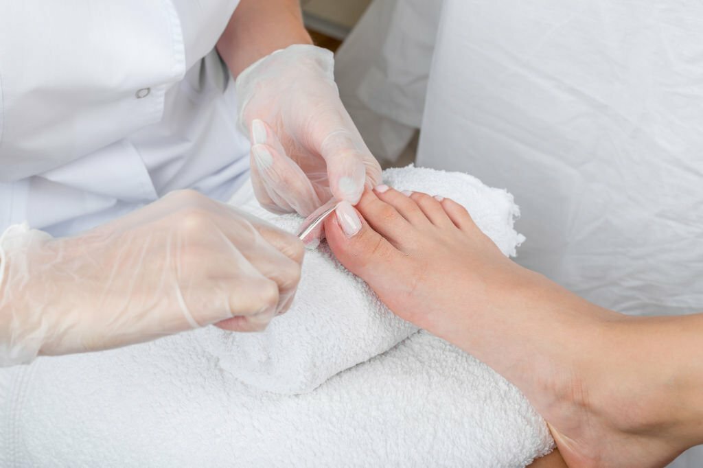 Manicurist uses tools for a pedicure